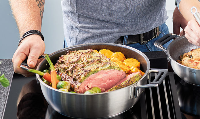 Serving pan with roast meat, vegetables and potato wedges