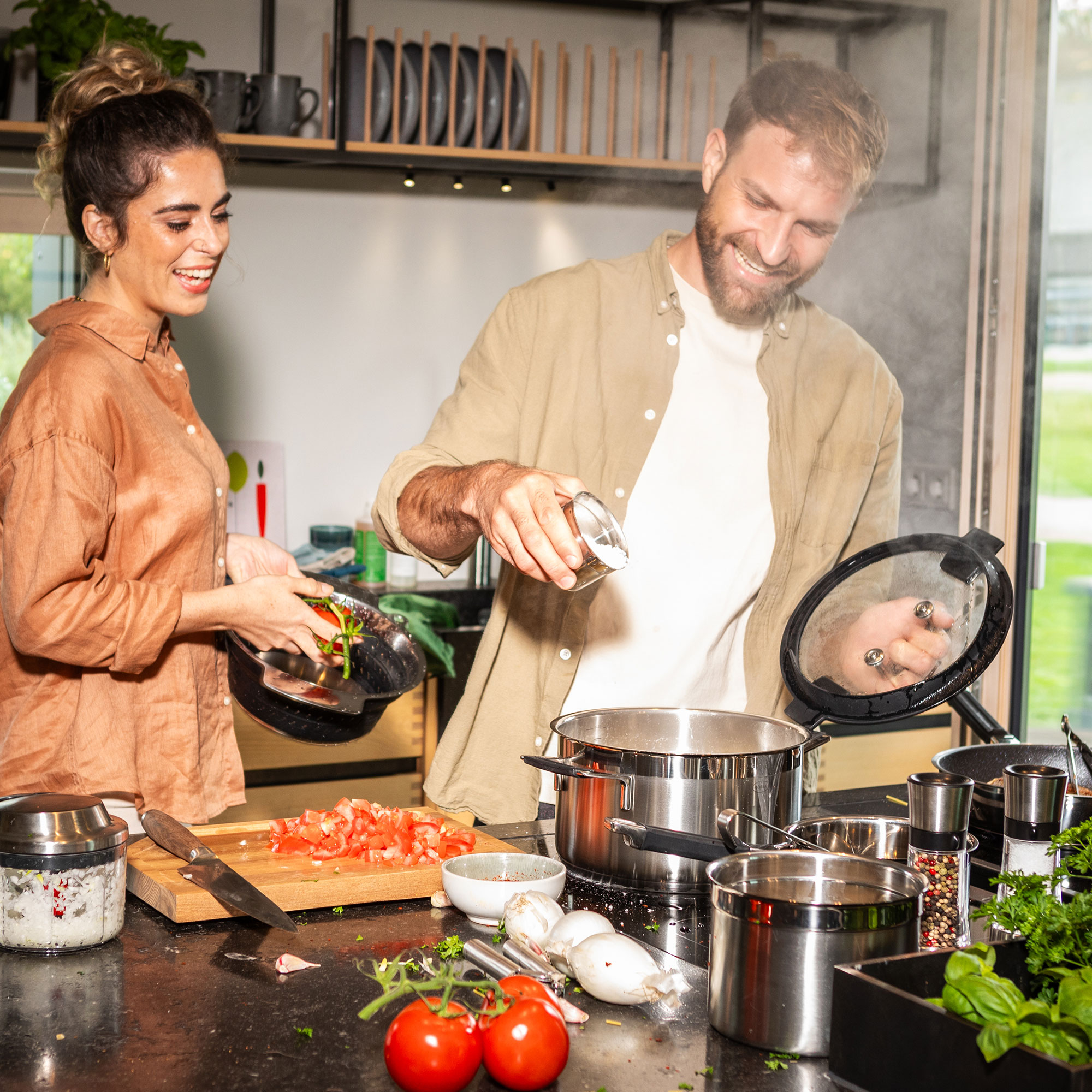Cooking scene with RÖSLE Profi Set Silence PRO Silence PRO professional set in a modern kitchen. A man and a woman prepare a meal together...