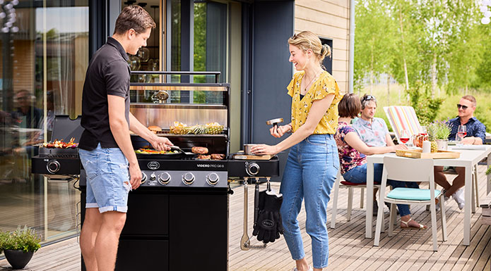 Couple barbecuing on the Videro G4-S PRO gas barbecue