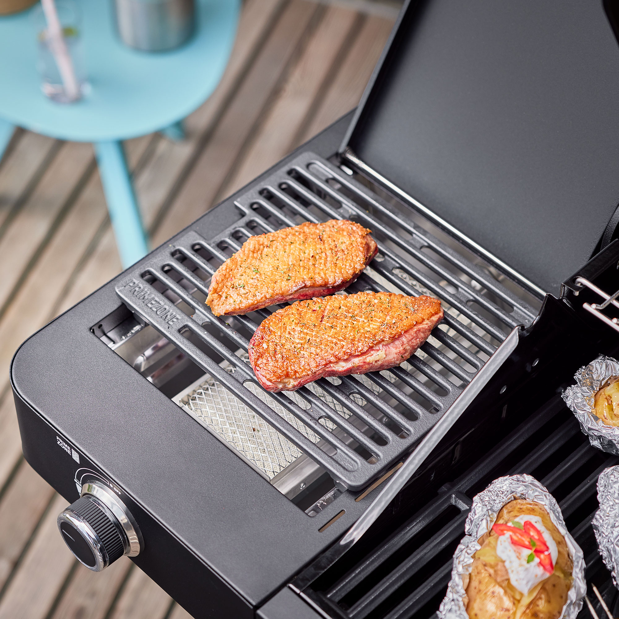 RÖSLE Gasgrill Videro G3-S PRO mit Grillgut Gasgrill Videro G3-S PRO mit zwei gegrillten Steaks auf dem Grillrost und gefüllten Kartoffeln...