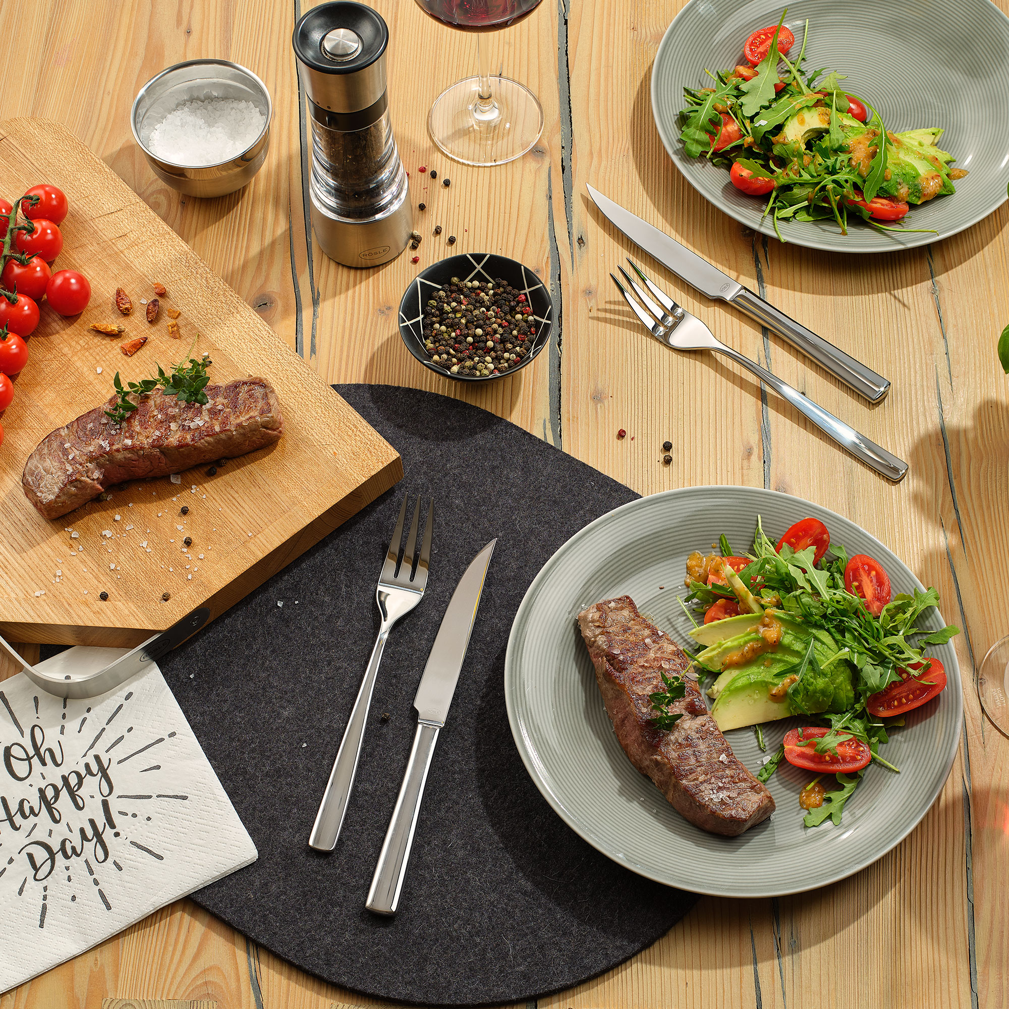 Steakbesteck Set Elegance von RÖSLE auf gedecktem Tisch Steakbesteck Set Elegance auf einem Tisch mit Steak, Salat und Tomaten.