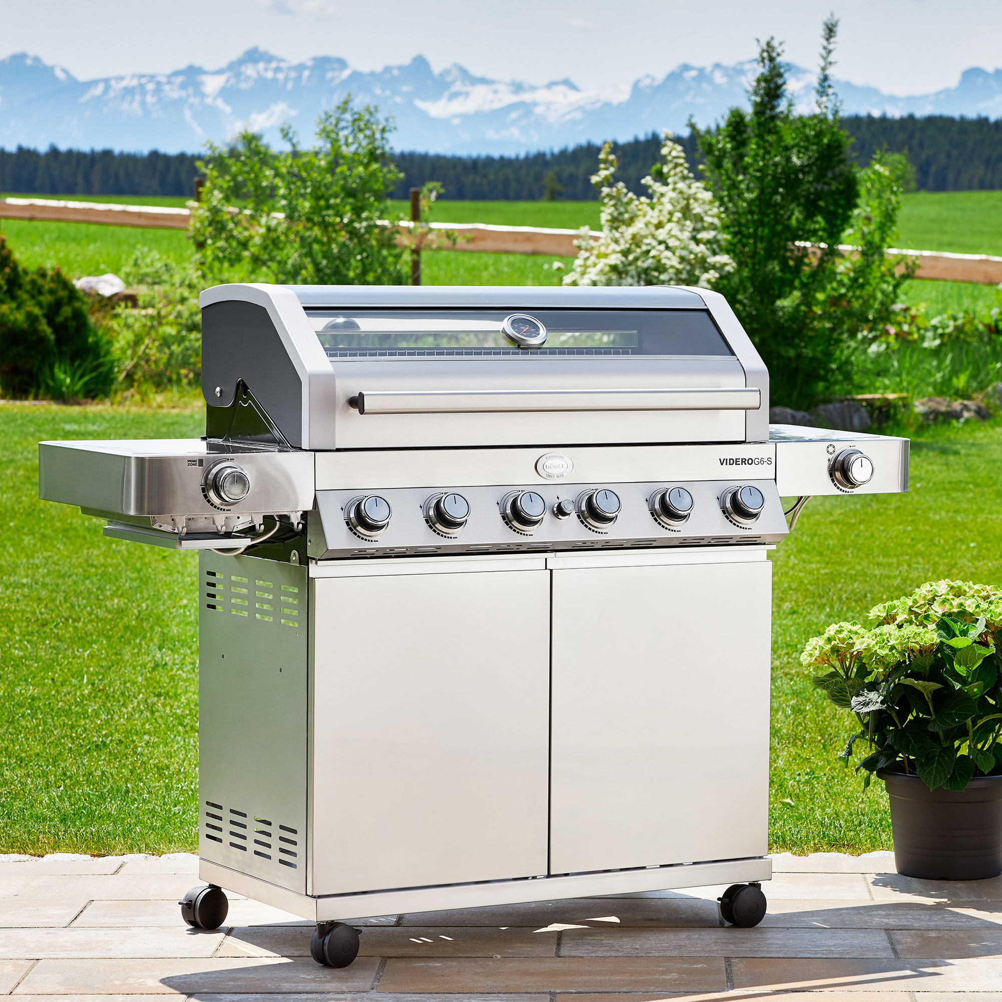 RÖSLE Videro G6-S Gasgrill Videro G6-S Gasgrill aus Edelstahl mit fünf Brennern und Sichtfenster, auf einer Terrasse...