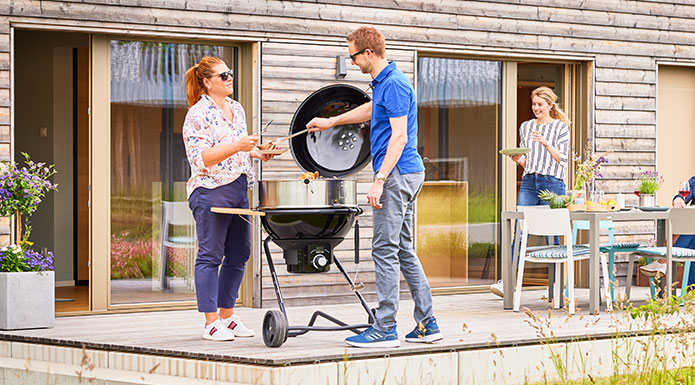 Freunde grillen zusammen auf dem Holzkohle Kugelgrill AIR