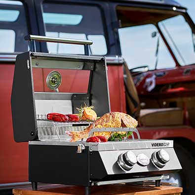 RÖSLE Gasgrill BBQ-Portable Videro G2-P Fischhalter mit gegrilltem Fisch auf Grillfläche des Videro G2-P