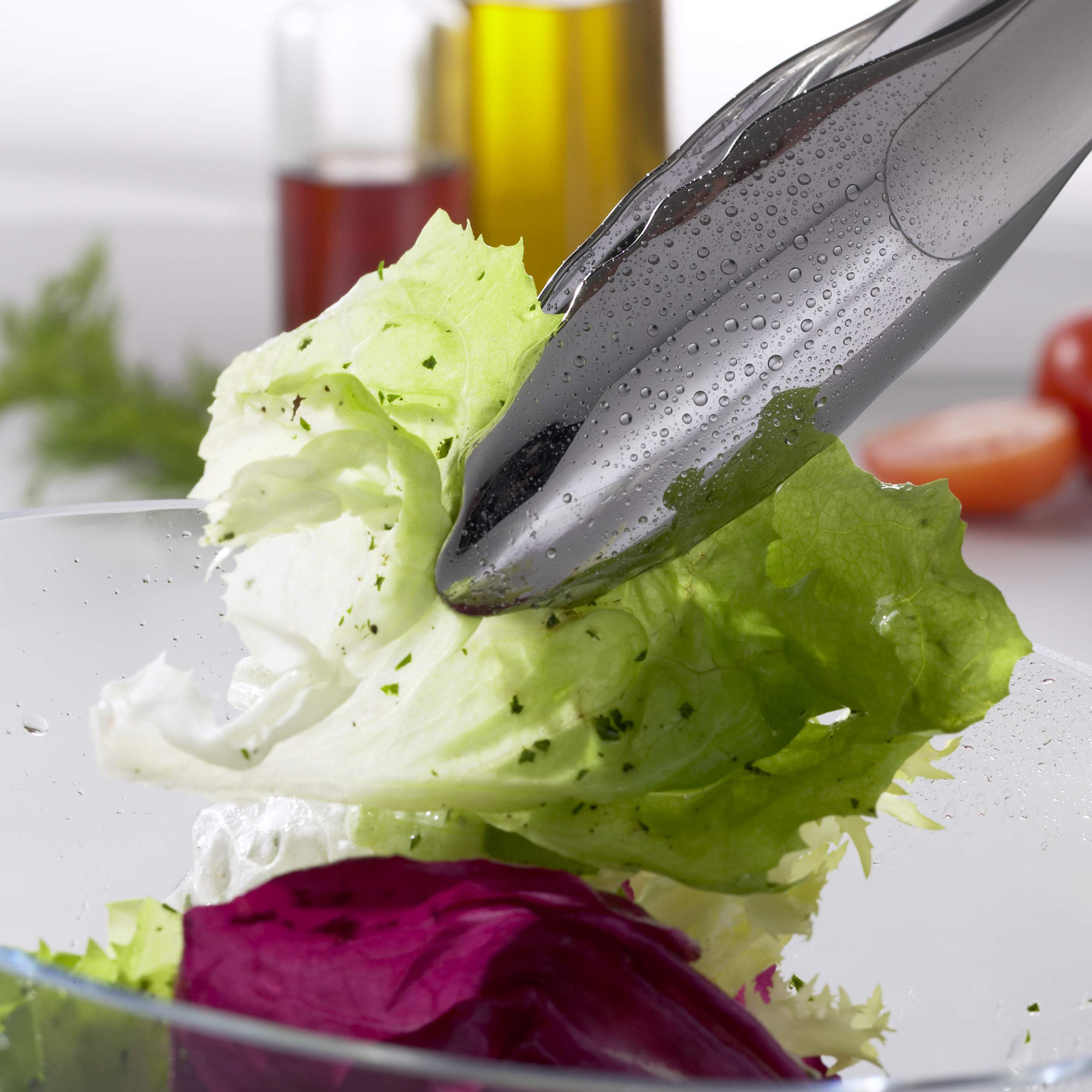 RÖSLE gourmet tongs 30 cm Stainless steel gourmet tongs, 30 cm, grips a fresh salad leaf in a bowl.