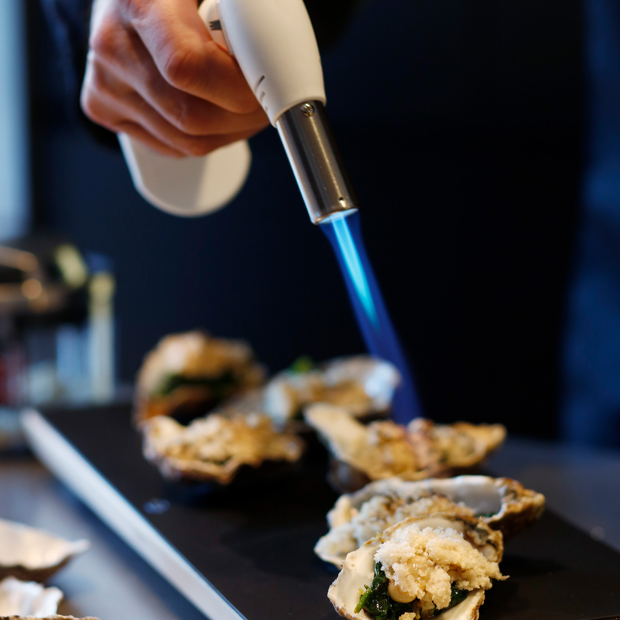 RÖSLE Flambierbrenner mit Austern Flambierbrenner in Gebrauch, um Austern zu flambieren.