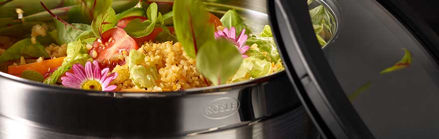 Vershoudblik met verse salade en groenten, gedeeltelijk geopend, gemaakt van roestvrij staal.