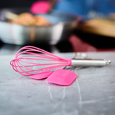 Schneebesen und Teigschaber Pink Charity auf einem Tisch