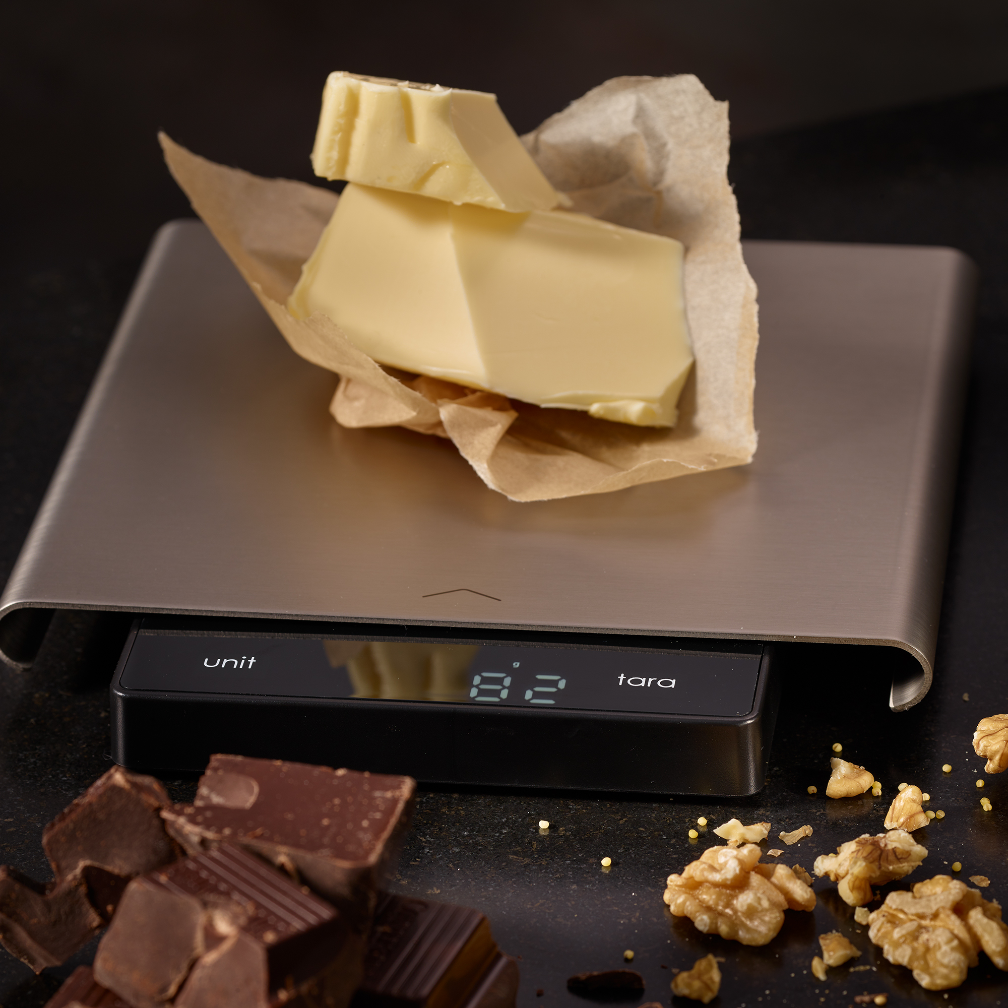 RÖSLE digitale Küchenwaage mit Butter und Snacks digitale Küchenwaage mit Slide-Funktion, auf der Butterstück auf Backpapier liegt, umgeben...