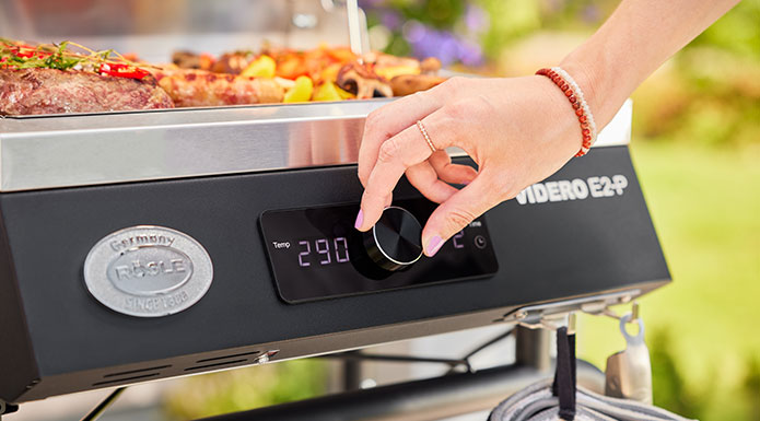 Elektrogrill E2-P Frau stellt Temperatur auf 290° im Elektrogrill E2-P ein.