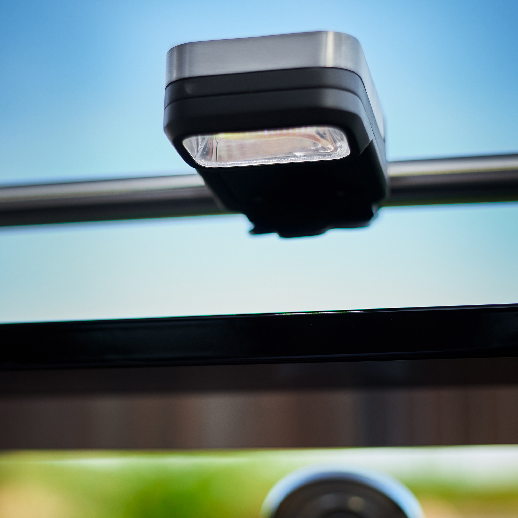 RÖSLE BBQ LED Griffleuchte Universal BBQ LED Griffleuchte, quadratische Form, schwarz und silber, montiert an einem Grill.