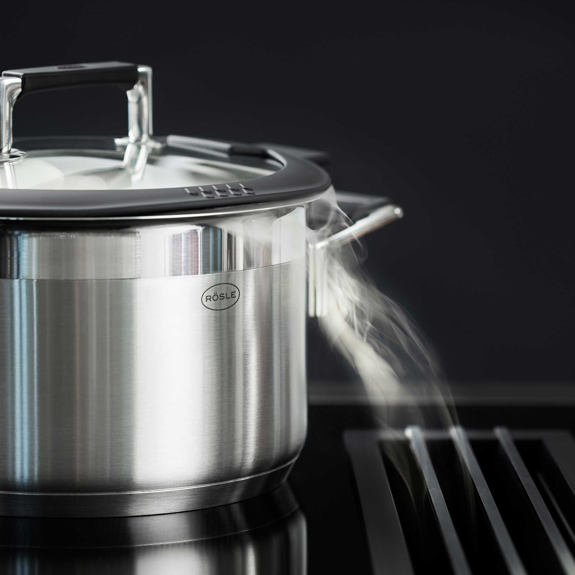 RÖSLE Topf Set Silence PRO Topf Set Silence PRO, Edelstahl, 5-teilig, Dampf entweicht aus einem Topf auf einem Kochfeld.