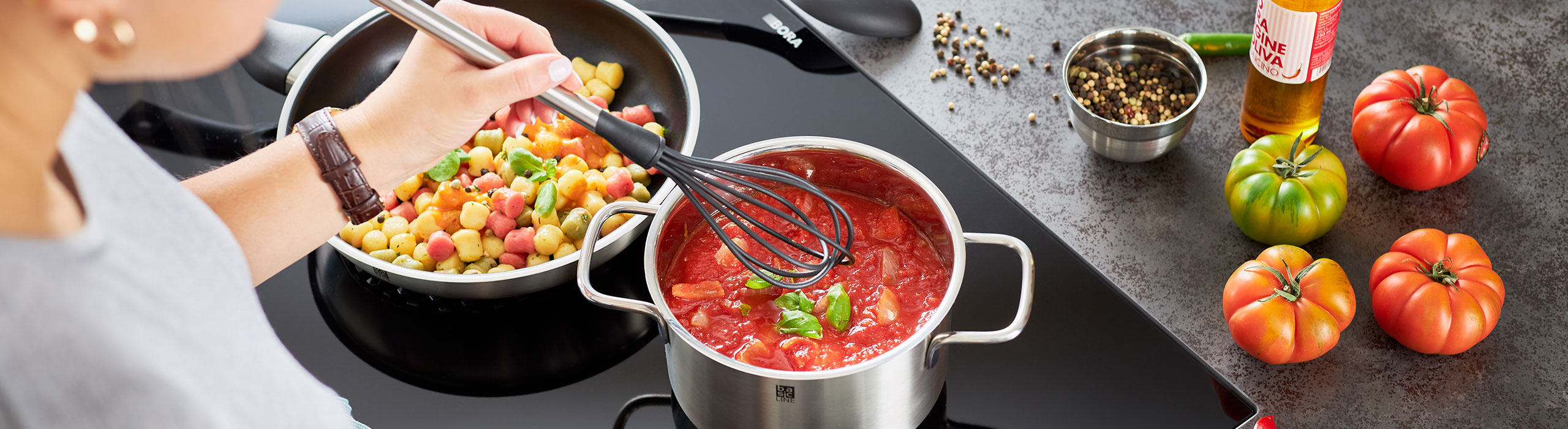 Tomato sauce in the saucepan and colorful gnoccis in the pan