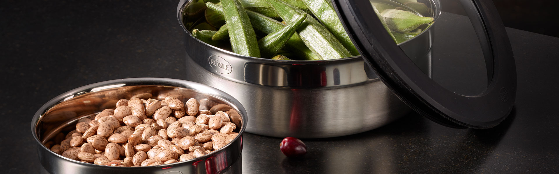 RÖSLE Edelstahlbehälter mit Lebensmitteln Edelstahlbehälter mit Deckel, gefüllt mit grünen Bohnen und Erdnüssen.