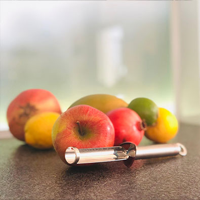 Fruchtenterkerner liegt mit Äpfeln auf Arbeitsplatte