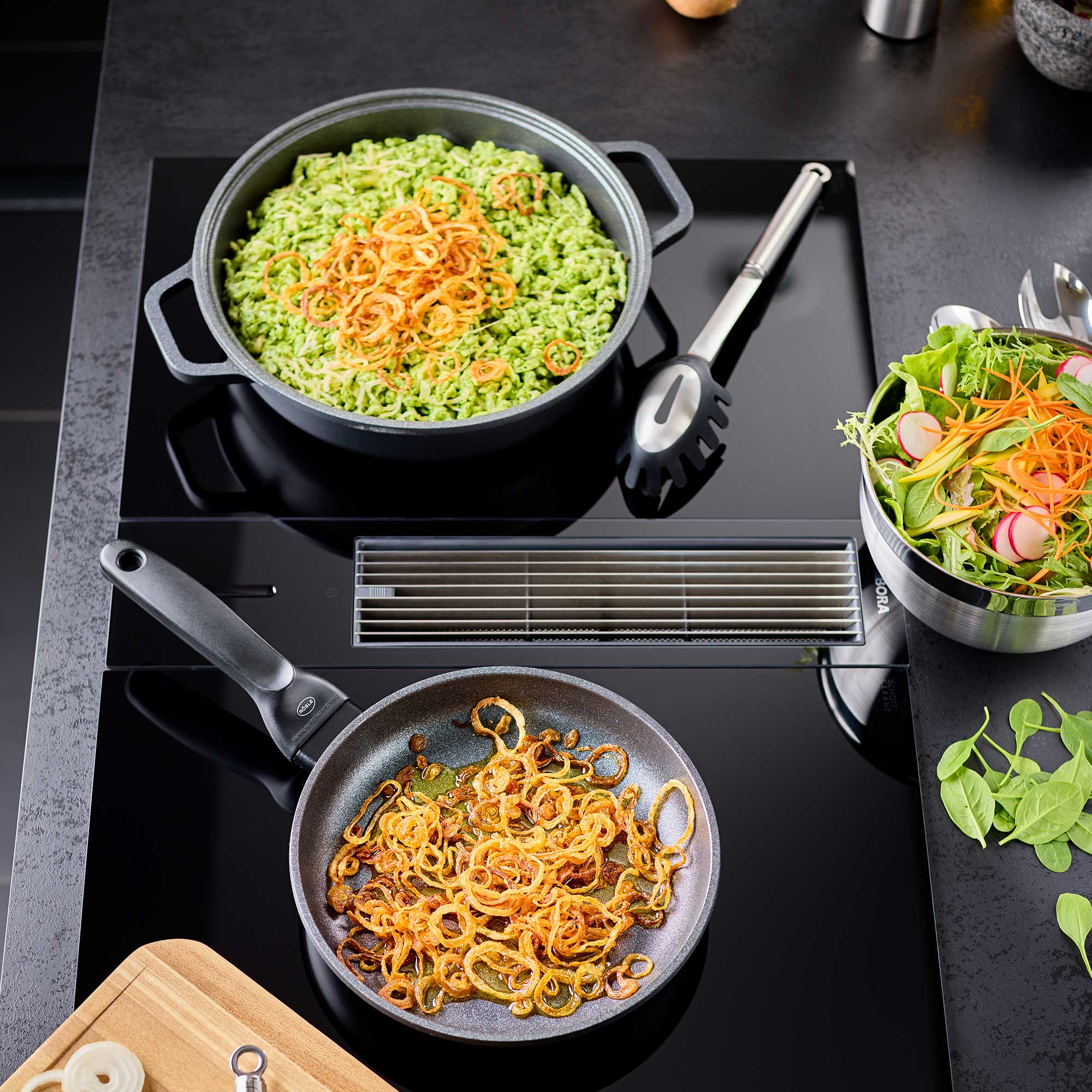 RÖSLE Servierpfanne Cadini mit Zwiebeln und Beilagen Servierpfanne Cadini, 28 cm, mit gebratenen Zwiebeln, neben einem Topf mit grünem Reis und...