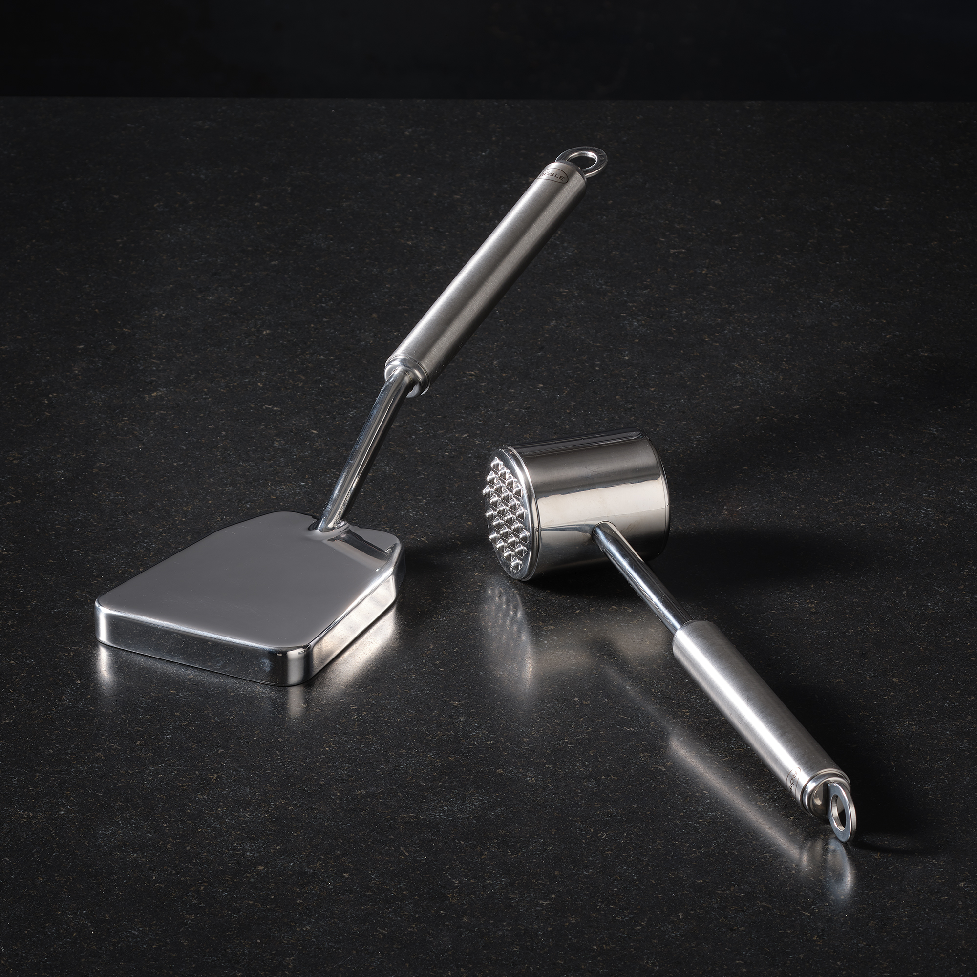 RÖSLE stainless steel meat hammer Stainless steel meat hammer, with flat and knobbed side, on black background.