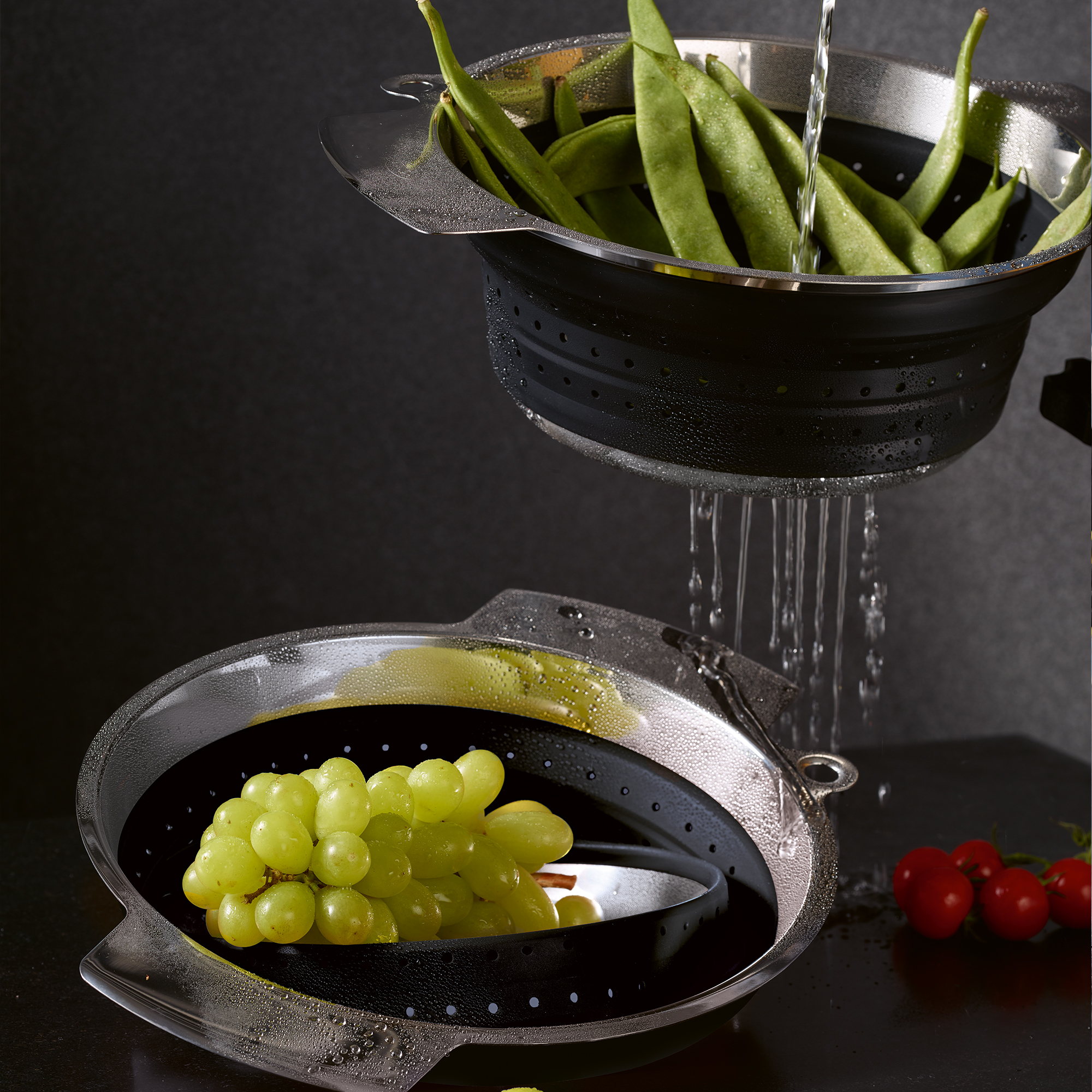 Faltbarer Seiher von RÖSLE faltbarer Seiher in Schwarz, aus Edelstahl und Silikon, mit grünen Bohnen und Trauben.