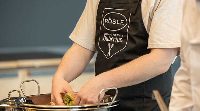 Grillschule Mann wäscht Salat mit RÖSLE und Hubertus Schürze