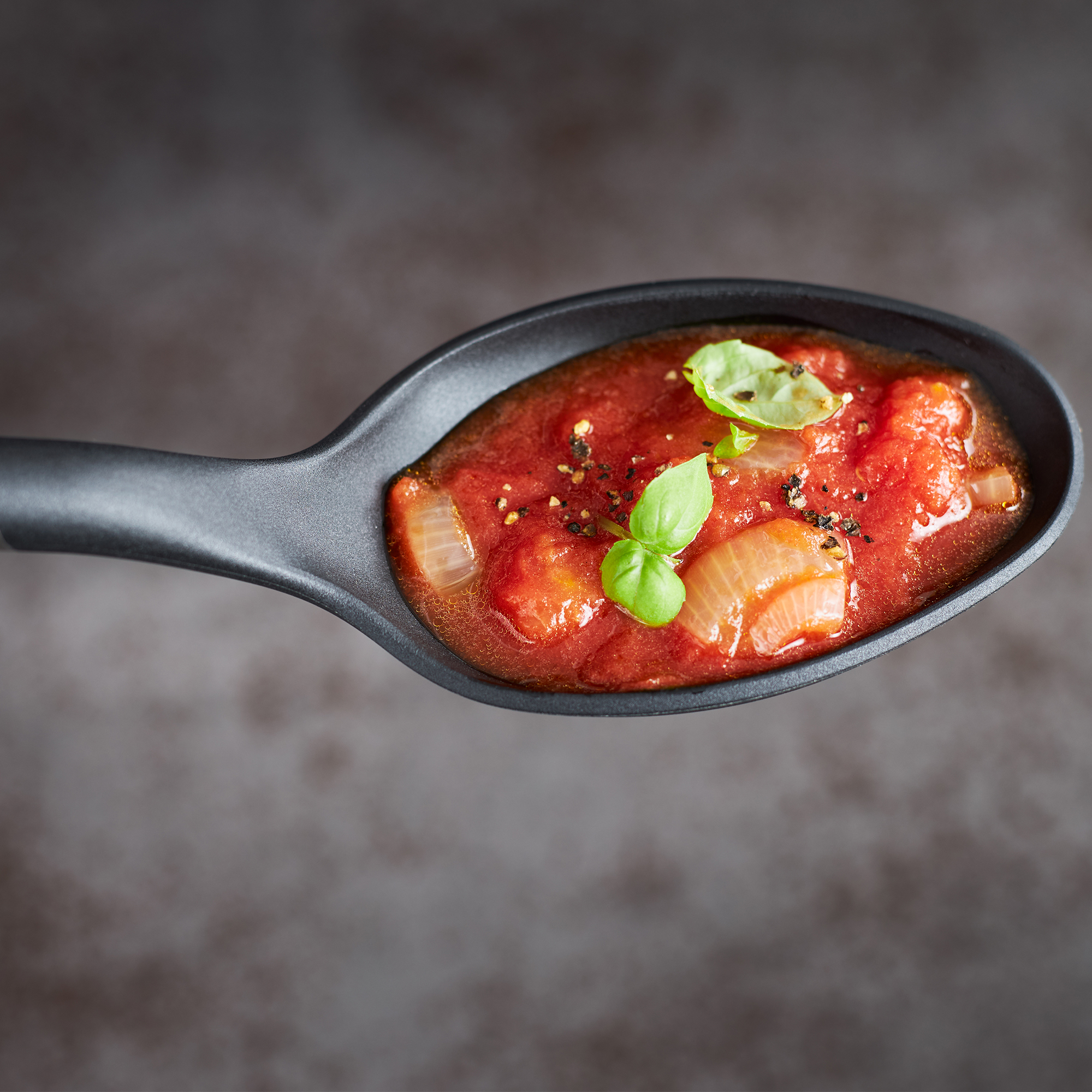 RÖSLE Giesslöffel 32 cm Basic Line Giesslöffel aus schwarzem Material mit Tomatensauce und Basilikumblättern