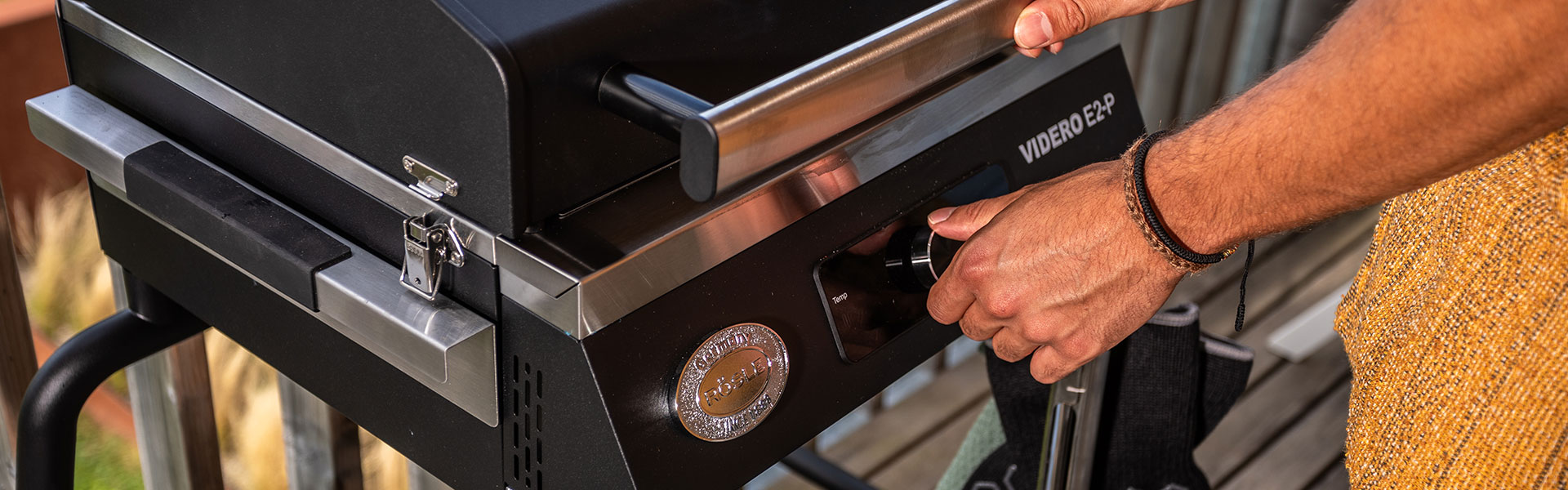 RÖSLE Elektrogrill mit Temperaturregler Elektrogrill mit einem Benutzer, der den Temperaturregler einstellt.