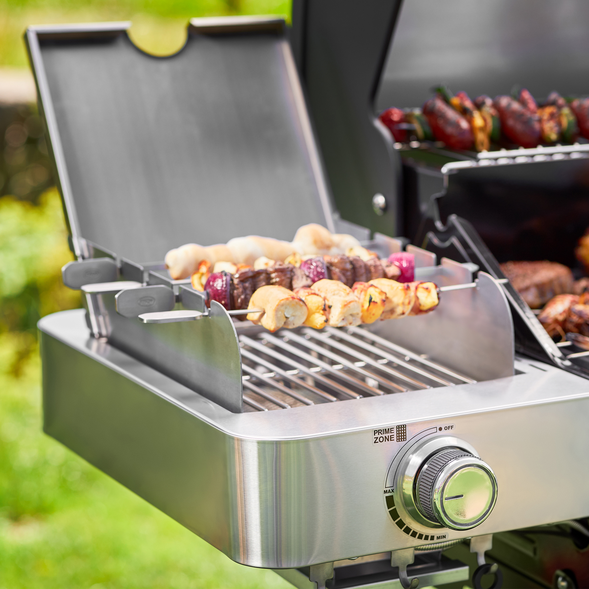 RÖSLE Primezone Windschutz für Videro Grill Primezone Windschutz für den Videro Grill, mit Spießen auf dem Grillrost.