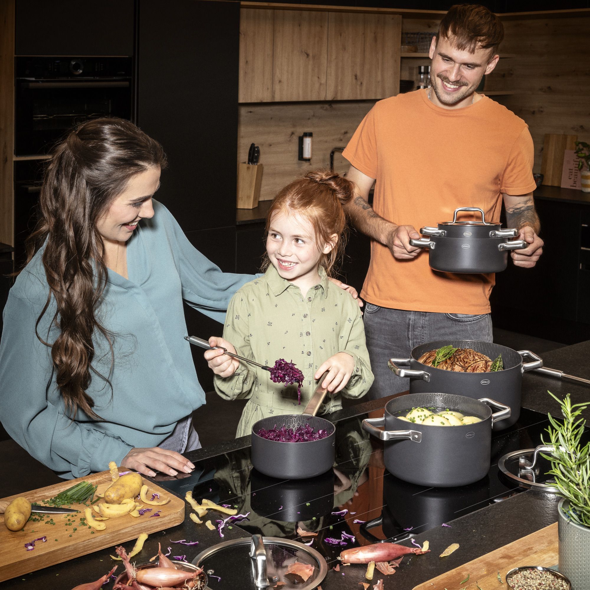 eine Familie die mit dem Bratentopf Ebonic ein Gericht kocht
