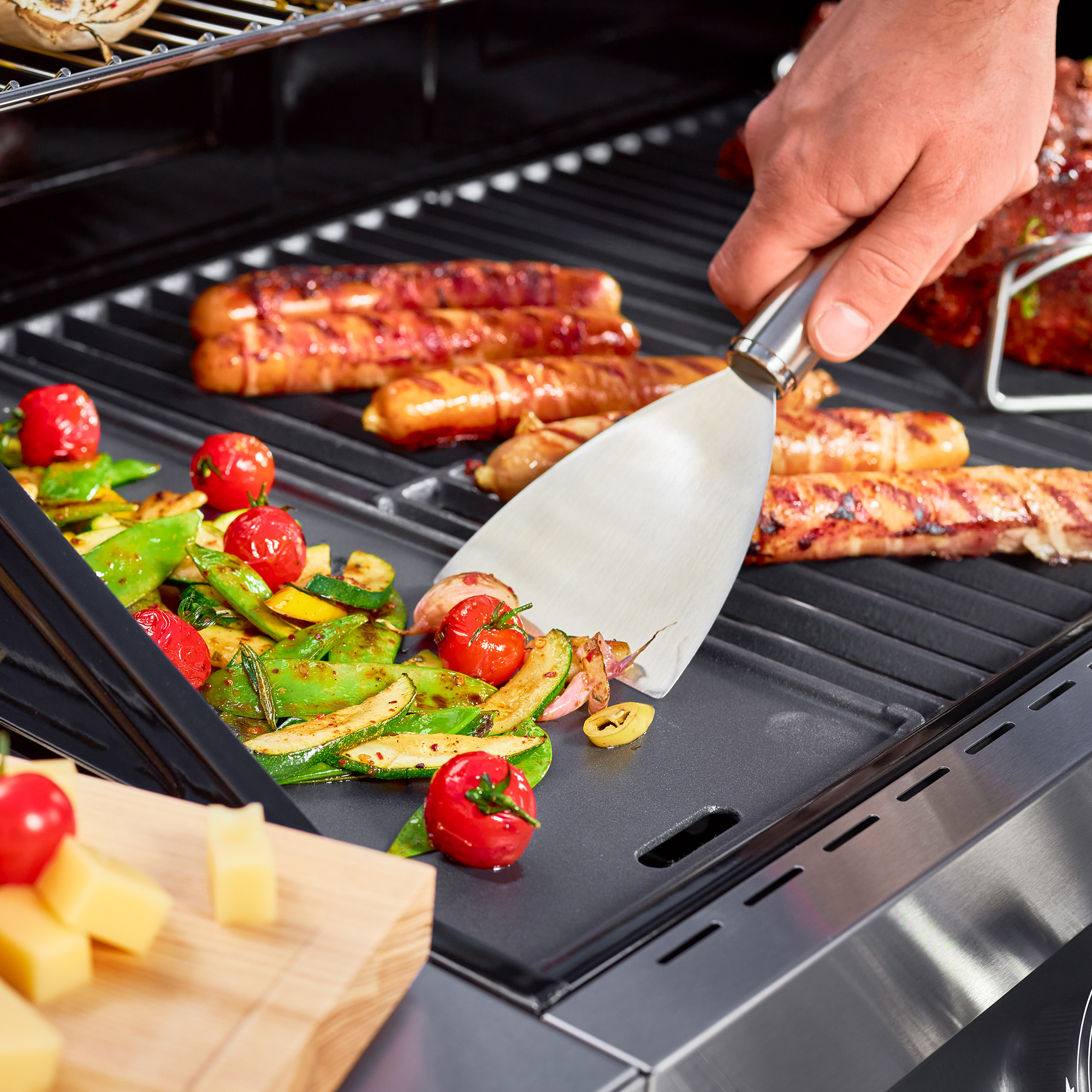 RÖSLE barbecue spatula in action Stainless steel barbecue spatula is used to turn vegetables and sausages on the barbecue.
