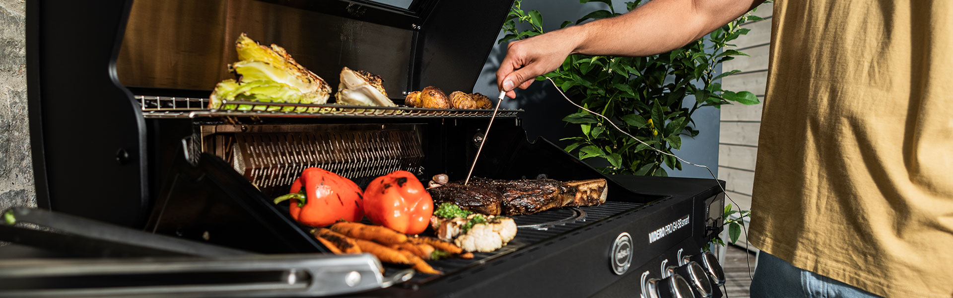 RÖSLE Grillthermometer in Aktion Grillthermometer wird verwendet, um die Temperatur eines Steaks auf einem Grill zu messen,...