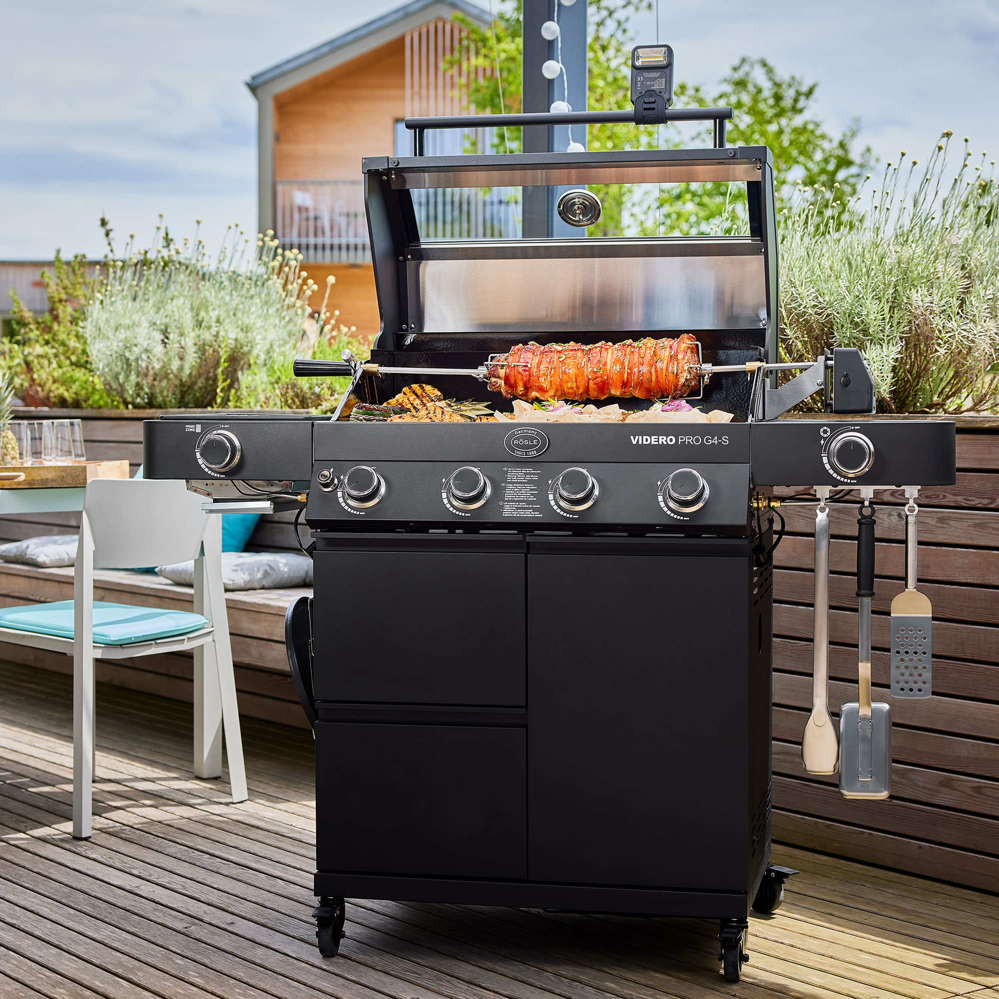 RÖSLE Gasgrill Videro G4-S PRO Gasgrill Videro G4-S PRO in Schwarz mit geöffnetem Deckel, Grillspießen und Zubehör.