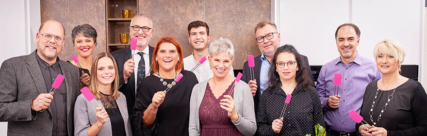 Rösle employees hold dough scraper Pink Charity