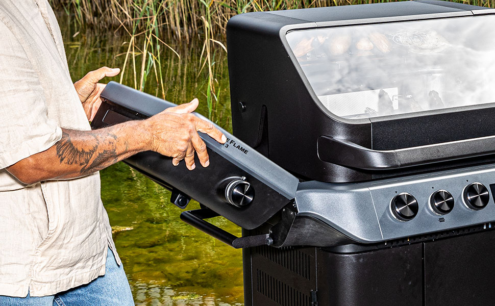 Seitentische Blazeflame Mann klappt Seitentisch des Blazeflame Grills nach oben ab.