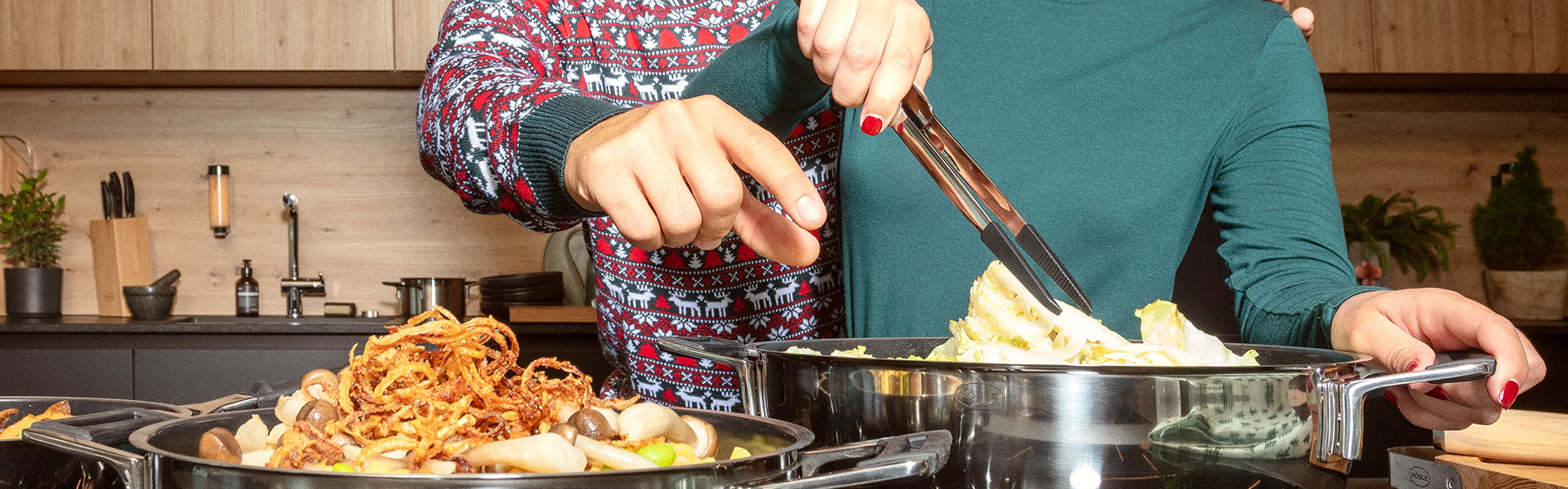 RÖSLE Zange beim Kochen Zange in Gebrauch, während zwei Personen gemeinsam am Kochen sind und Zutaten in einen Topf...