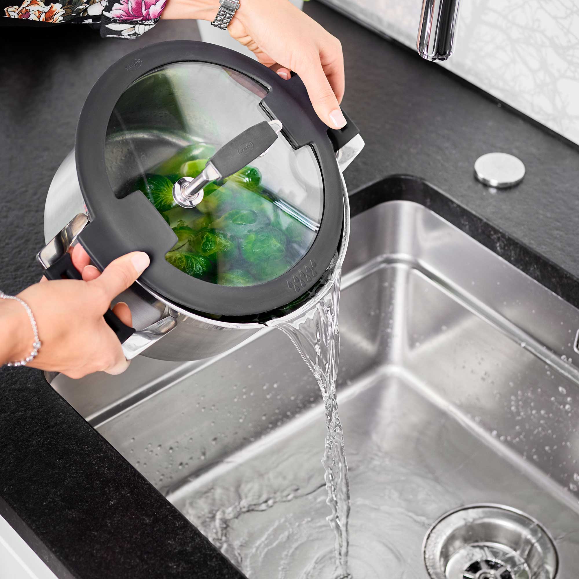 RÖSLE Kochtopf Silence PRO 24 cm Kochtopf Silence PRO mit Glasdeckel, beim Abgießen von Gemüse über die Spüle.