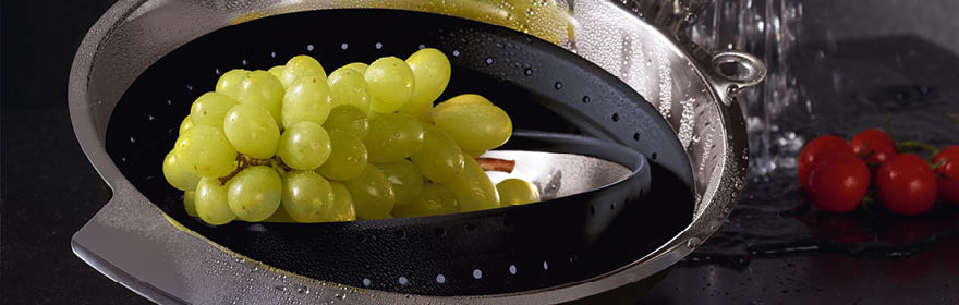 RÖSLE roestvrijstalen vergiet met siliconen rand Roestvrijstalen vergiet met zwarte siliconen rand, met druiven en tomaten.